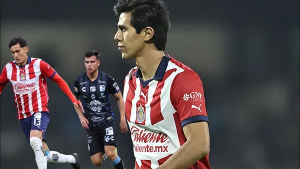 Macías viendo como Chiquete disputa un balón