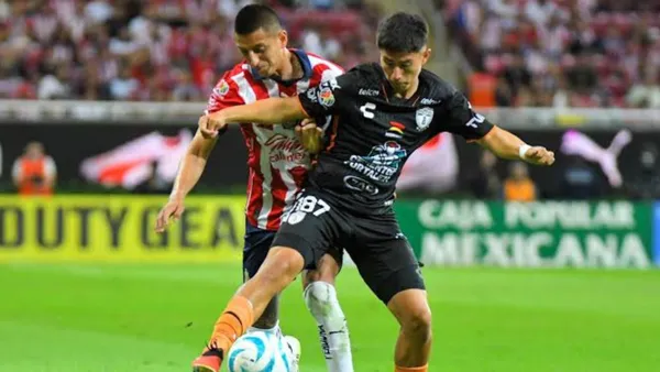 Piojo Alvarado disputando un balón con jugador de Pachuca