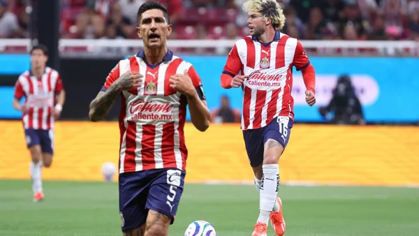 Pocho celebrando y Cowell conduciendo el balón