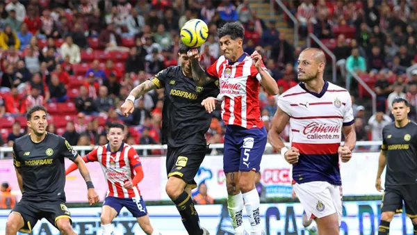 Pocho Guzmán peleando un balón vs Toluca y Chicharito