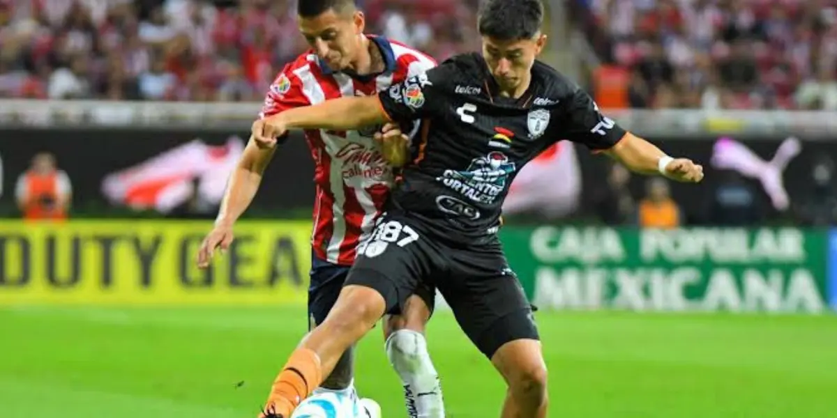 Piojo Alvarado disputando un balón con jugador de Pachuca